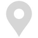 A simple gray map location pin icon with a circular cutout in the center, displayed on a light background.